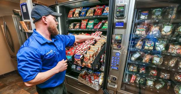 Technician restocking a snack machine