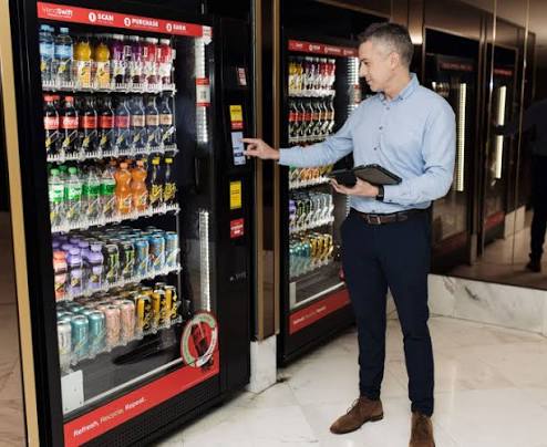 Employee using a modern glass-front vending machine